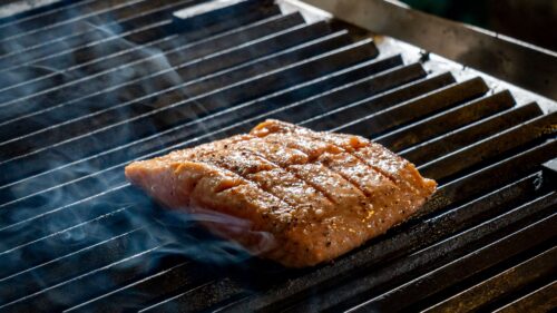 Zalmfilet met grillstrepen gaart op het rooster van een kamado