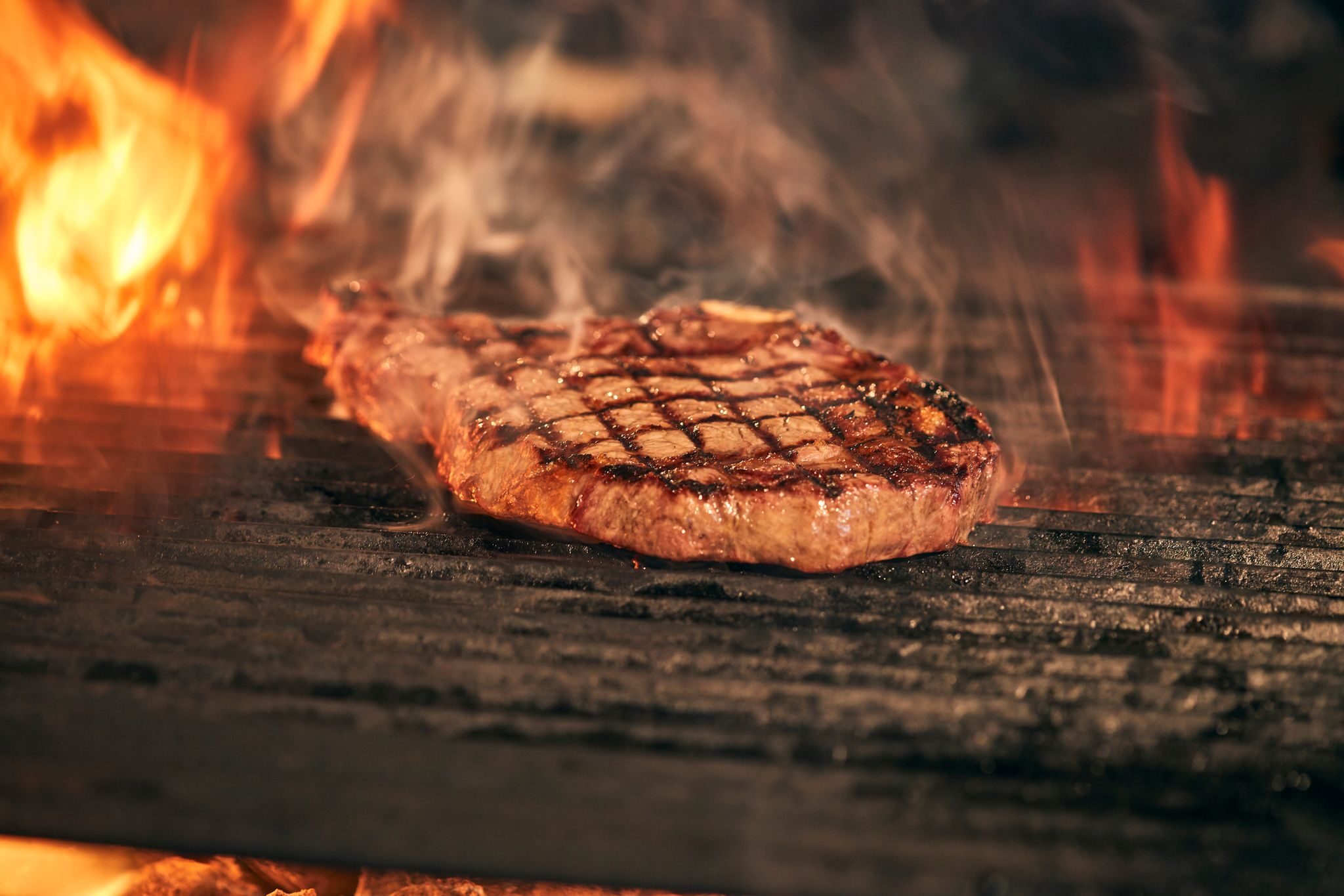 Ribeye wordt boven open vuur dichtgeschroeid met duidelijke grillstrepen